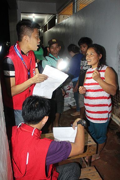 DSWD-7 staff distribute sleeping kits to landslide-affected families at the Sirao Integrated School in Barangay Sirao, Cebu City.  (CONTRIBUTED PHOTO) 
