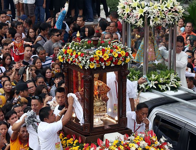 Hundreds of devotees wave their hands at the image of the holy child Sto. Niño and his mother Our Lady of Guadalupe as they leave the basilica to St. Joseph shrine in Mandaue City for today's fluvial procession during the start of the traslacion (CDN PHOTO/JUNJIE MENDOZA). 