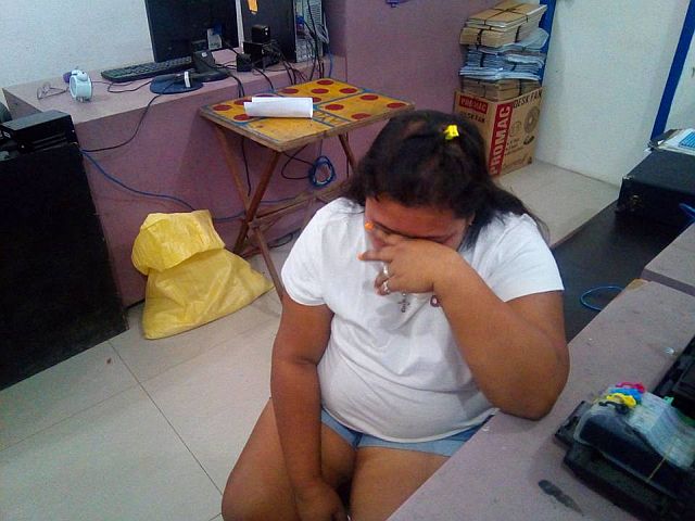 Marites Quinio, 27, covers her face while being interrogated at Talisay City Police Office. (TALISAY CITY POLICE FACEBOOK PAGE)