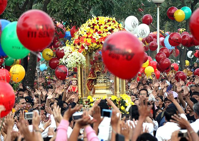 SINULOG 2011 FLUVIAL PARADE/JAN.15,2011:Devotees of the Snr Sto Niño wave their hands as the image pass them to board the Galleon to transport from Mandaue City Ouano wharf to Cebu City Port during the Sinulog 2011 fluvial parade.(CDN PHOTO/LITO TECSON)
