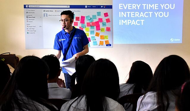A Globe employee volunteer conducts a DTP workshop for high school students. (CONTRIBUTED PHOTO)