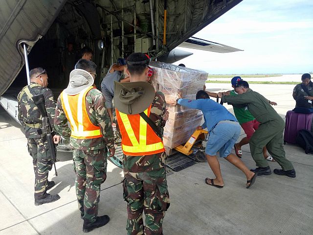 Military personnel unload family food packs from the C130 plane. (CONTRIBUTED PHOTO)