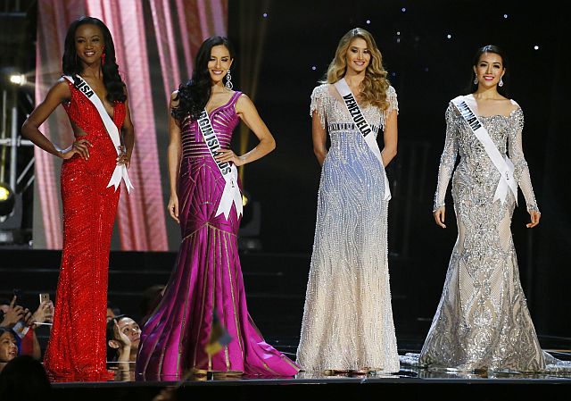 Miss Universe contestants, from left, Deshauna Barber of the United States, Carolyn Carter of THE U.S. Virgin Islands, Mariam Habach of Venezuela and Le Hang of Vietnam, pose during the evening gown preliminary competitionof the Miss Universe beauty pageant at the Mall of Asia Arena Thursday, Jan. 26, 2017 in suburban Pasay city south of Manila, Philippines. A total of 86 contestants are vying for the title in the grand coronation on Jan. 30 to succeed Pia Wurtzbach of the Philippines. (AP Photo/Bullit Marquez)