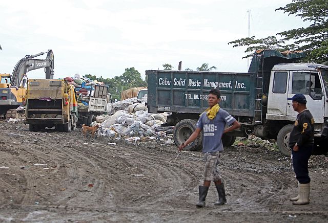 A garbage truck from a Cebu City barangay dumps trash in a private lot near Inayawan. (CDN PHOTO/LITO TECSON)