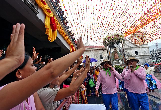 Devotees wave to the Holy Child as it is being brought inside the Basilica Minore del Santo Niño Pilgrim Center for the reenactment of the first Mass, baptism and wedding on Jan. 14, 2017. (CDN PHOTO/JUNJIE MENDOZA)