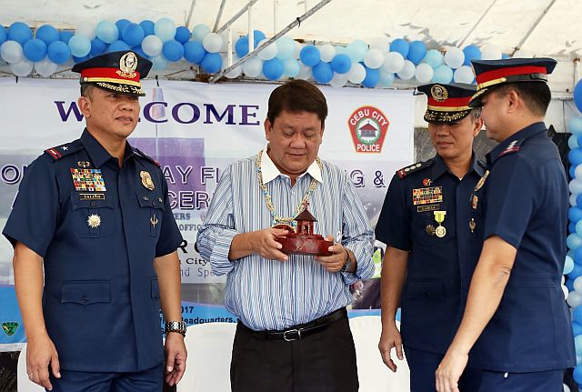 Mayor Tomas Osmeña (second from left) receives a token from Senior Supt. Joel Doria, Cebu City Police Office chief, (right) in Camp Sotero Cabahug in Cebu City. Chief Supt. Noli Taliño (left), regional police chief, and Senior Supt. Rey Lyndon Lawas, regional deputy director for operations, also attended the event. (CDN PHOTO/JUNJIE MENDOZA)