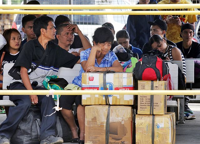 Both domestic and foreign passengers wait for word on their trips outside the Pier 1 terminal in the Cebu City port area. (CDN PHOTO/JUNJIE MENDOZA)