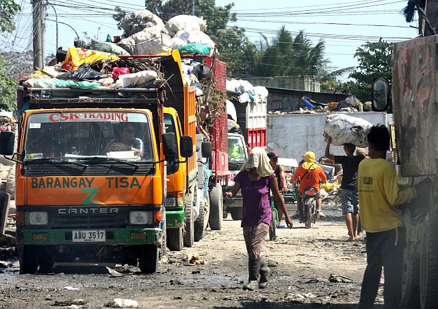 Garbage trucks from Cebu City’s barangays wait in line for their turn to dump their collected waste at the private landfill in Barangay Inayawan, Cebu City. (CDN PHOTO/JUNJIE MENDOZA)