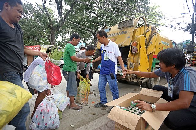 Members of Cebu City’s Department of Public Services (DPS) conduct a test run for the city’s plans to exchange one can of sardines for every bag of trash collected by residents in areas that could not be reached by garbage trucks. On Monday, DPS tried the garbage collection scheme on residents of Sitio Riverside, Barangay Lahug. (CDN PHOTO/LITO TECSON)