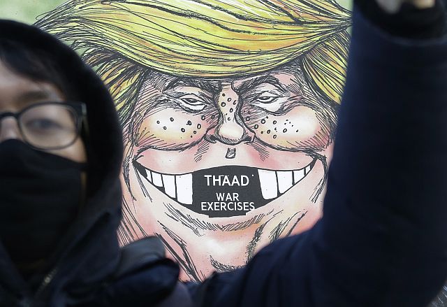 A South Korean protester stands in front of a caricature of US President Donald Trump during a rally against US Defense Secretary Jim Mattis’ visit, in front of the government complex in Seoul, South Korea, in this February 2, 2017 photo.  /AP