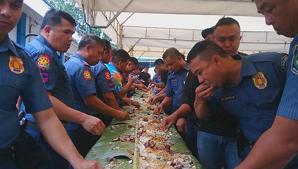 PRO-7 officials led by Chief Supt. Noli Taliño (second from left) join other policemen from the Mandaue City Police Office in a boodle fight. cdn photo/norman mendoza 