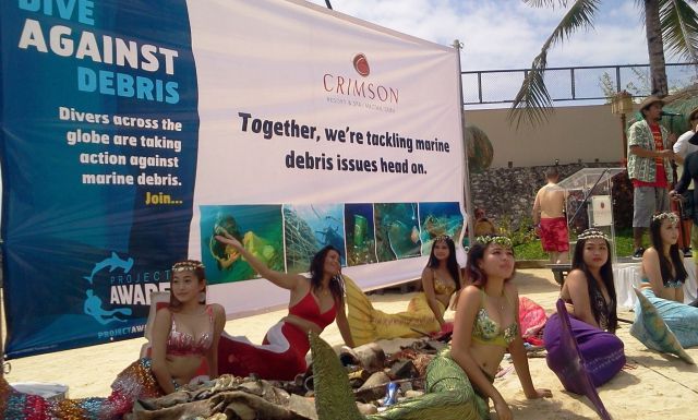 Divers gather the trash that they retrieved during the “Dive Against Debris” underwater cleanup at Crimson Resort in Lapu-Lapu City as women dressed as mermaids pose for a photo shoot. / (CDN PHOTO NORMAN MENDOZA)