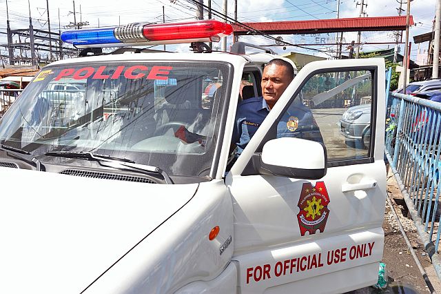 SPO1 Adonis Dumpit prepares to board a police mobile vehicle assigned to the Carbon Police Station, which has jurisdiction over Barangay Ermita. (CDN PHOTO/JUNJIE MENDOZA)