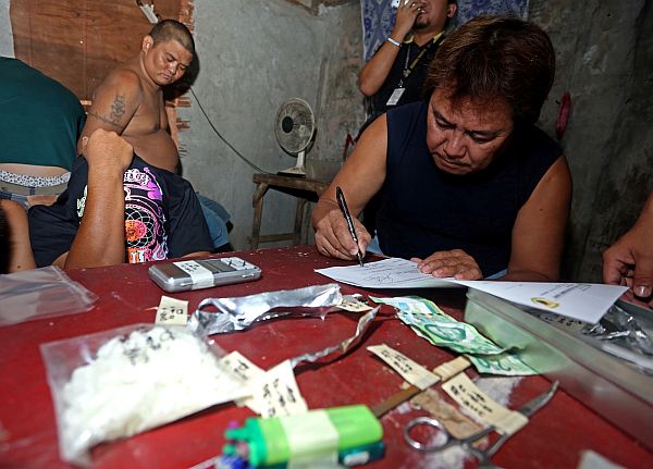 Duljo barangay chairman Elmer Abella signed the inventory of the raiding team of the Philippine Drug Enforcement Agency (PDEA) in their area. Barangay officials are being called to cooperate with the government’s campaign against illegal drugs.  CDN Photo/Lito Tecson