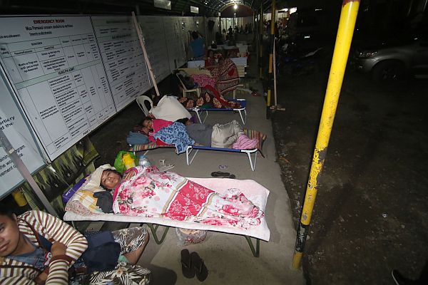Hospital patients take shelter in a pedestrian waiting shed for safety after a 6.7-magnitude earthquake struck overnight in Surigao City, in southern island of Mindanao, February 11, 2017.