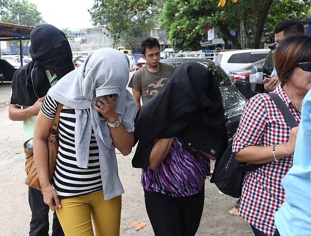 Three employees of a manpower recruitment agency,  Feljobs Manpower Services, are brought to the Criminal Investigation and Detection Group office in Cebu City after their Basak office was raided for illegal recruitment and for operating without legal documents. (CDN PHOTO/JUNJIE MENDOZA)