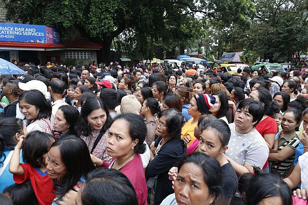 Residents gather outside the city hall of earthquake-hit Surigao City as they await for the government’s relief assistance.  Inquirer photo