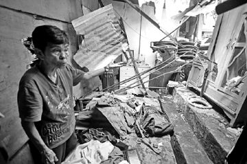 Segundina Cavan, 76, shows a portion of her house that was damaged after the crane fell on it. CDN PHOTO/LITO TECSON