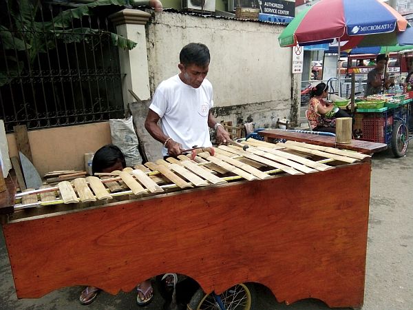 On a sidewalk in downtown Cebu City, Anselmo “Doy” Tamparong would play different love songs to entertain passersby using a bamboo xylophone  locally known as “gabbang.”  CDN PHOTO/Jheysel Ann Tangaro