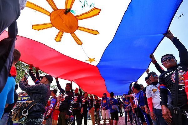 pro-Duterte supporters foist the Philippine flag as a show of patriotism.