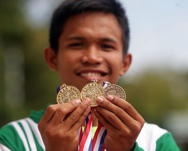 Leo Bendejo of Bohol proudly shows his harvest of two golds and a bronze from track and field. (CDN PHOTO/TONEE DESPOJO)