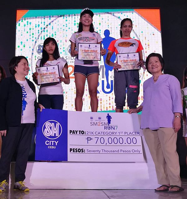 Mary Joy Tabal (middle) at the top of the podium after winning her fifth straight 21k title in the SM2SM Run. She is joined by (from left) SM Prime Holdings Inc. vice president Marissa Fernan, third placer Cristabel Martes, second place Ruffa Sorongon and CENEWOF chairman Dr.Pureza Onate. Christian Maningo