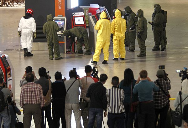 Hazmat crews investigate the check in kiosk machines at Kuala Lumpur International Airport 2 in Sepang, Malaysia on Sunday, Feb. 26, 2017. Malaysian police ordered a sweep of Kuala Lumpur airport for toxic chemicals and other hazardous substances following the killing of Kim Jong Nam.  AP Photo