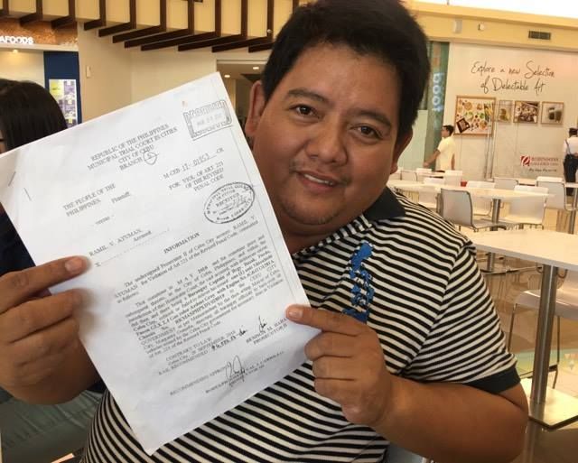 Apas Barangay Captain Ramil Ayuman shows a document from the Cebu City Prosecutor's Office formally charging him and six other barangay captains before the MTCC for violation of Article 221 of the RPC or the failure to make delivery of public funds or property. (CDN PHOTO/JOSE SANTINO S. BUNACHITA)
