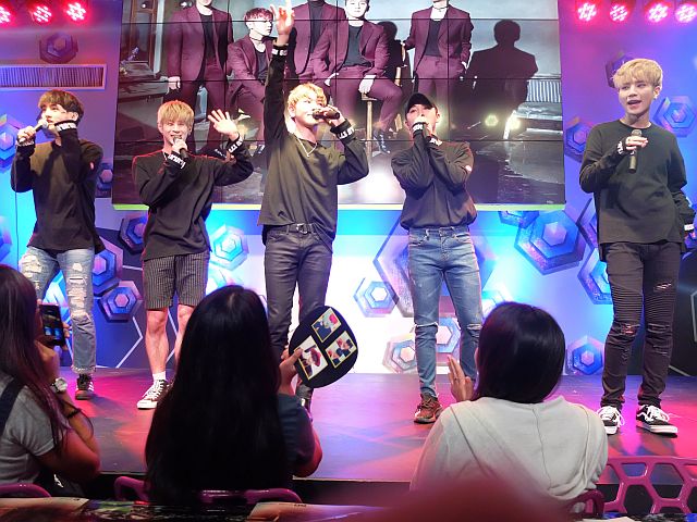From left: Doa, Juno, Junghoon, Daeyoung, Honey during their fanmeet at KpubbHoney accepting tissue from a fan