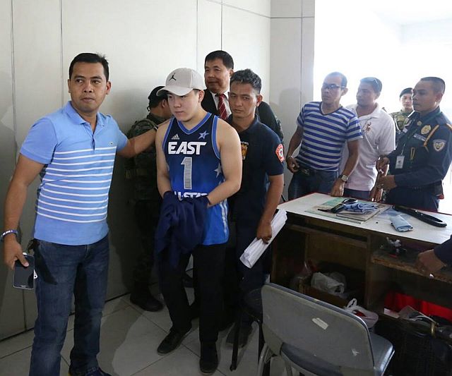 David Lim Jr. escorted by police officers arrives at the Palace of Justice to post bail. (CDN PHOTO/JUNJIE MENDOZA)