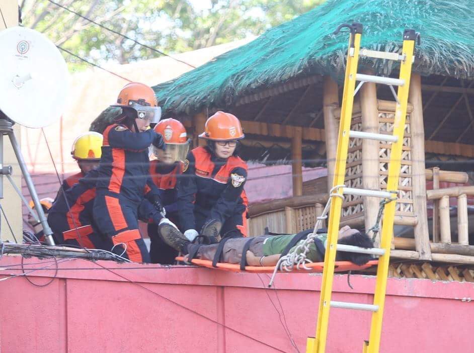 Firefighters demonstrate how to rescue a fire victim. (CDN PHOTO/LITO TECSON)