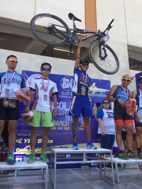 Joland Olmilla raises his mountain bike in celebration during the awarding ceremony of the 1st Consolacion Mountain Bike Duathlon at SM Consolacion in Consolacion town, northern Cebu. CONTRIBUTED PHOTO
