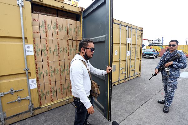Coast Guard personnel guard container vans of Mighty cigarettes, which were earlier confiscated after being found to bear fake tax stamps at Pier 4 in Cebu City. CDN PHOTO/JUNJIE MENDOZA