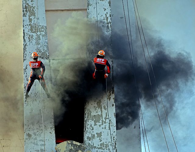 Firefighters rappel to check a burning building during a fire drill. (CDN PHOTO/LITO TECSON)