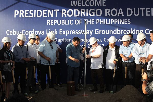 President Rodrigo Duterte (fifth from left) and Manny Pangilinan, Metro Pacific Tollways Development Corp.  (MPTDC) chairman (sixth from left), lead the lowering of the time capsule during the groundbreaking of the Cebu-Cordova Link Expressway in Barangay Pilipog in Cordova town. Cebu City Gov. Hilario Davide III  and Cordova Mayor Mary Therese Sitoy-Cho (left) were among the government officials who attended Thursday’s event. PHOTO/JUNJIE MENDOZA