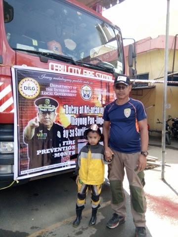 Edgar Rosales, 50, pose for a picture with his 10-year-old grandson Prince John during the opening of the observance of Fire Prevention Month last March 1.(CDN PHOTO/FE MARIE DUMABOC)