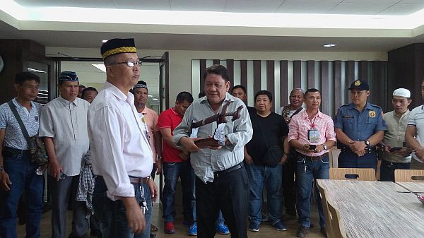 Sultan Ayaon R. Punut, Executive Assistant II of the Office of the Muslim Affairs and Indigenous Cultural Communities (OMAICC), gives Cebu City Mayor Tomas Osmeña a kris (moro sword) as a symbol of unity.  