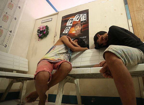 Minors who were arrested during a drug bust take a nap inside the Mabolo Police Station. Police were told to turn them over to the Department of Social Welfare and Services of the Cebu City government.  CDN PHOTO/LITO TECSON