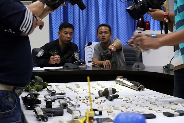 Supt. Mario Baquiran  and PO2 Luchin Denopol (top) of the Cebu Provincial Police Office show the confiscated items to local media. (CDN Photos/Junjie Mendoza)
