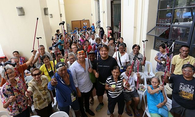 forum participants raise their crutches as they pose for a group photo with Cebu City Councilor Jerry Guardo (fourth from left in the front). (CDN PHOTOS/JUNJIE MENDOZA)