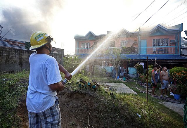 A firefighter battles the morning fire in Barangay Punta Princesa in Cebu City which destroyed 10 houses. (CDN PHOTO/LITO TECSON)