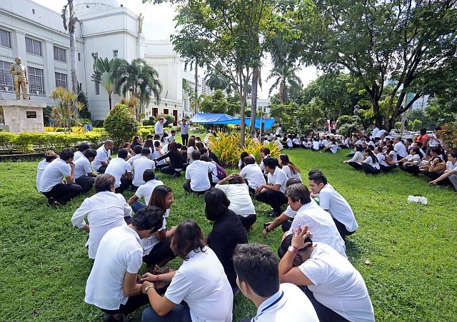 Capitol employees await further instructions while seated on the grass outside the Capitol building during last year’s earthquake drill.  (FILE PHOTO)