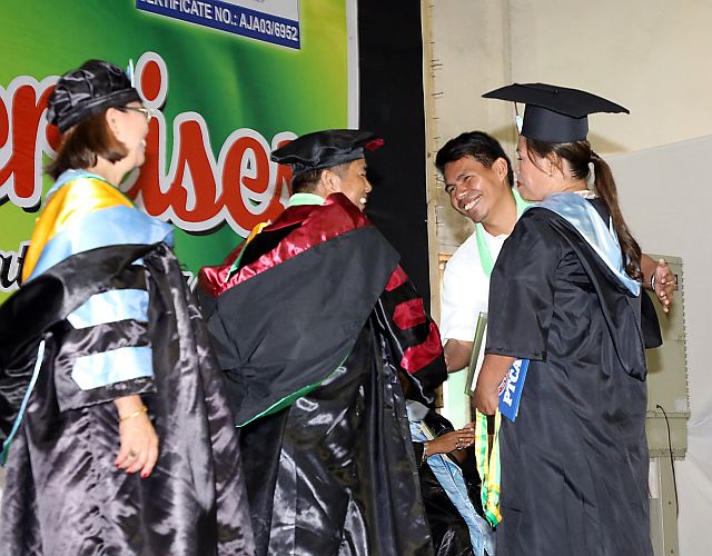 Juana Caminade Villegas (right), 56, achieves her dream of graduating from college as she receives her diploma for completing the Bachelor of Secondary Education at the Cebu Technological University Argao campus. (CDN PHOTOs/TONEE DESPOJO)