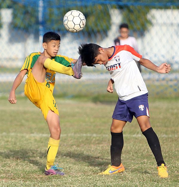 A University of San Carlos player misses the ball and ends up hitting the head of his opponent from  Forza FC/Football Fanatics in  yesterday’s action of 1st Hyundai Football Cup. CDN PHOTO/LITO TECSON