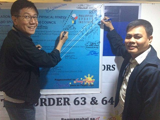 Edward Hayco (left), chairman of the Cebu City Sports Commission, and lawyer Ramil Abing, chairman of Cebu Provincial Sports Commission, sign a manifesto signifying their support to the programs of the Philippine Sports Commission. (CDN PHOTO/CALVIN D. CORDOVA)
