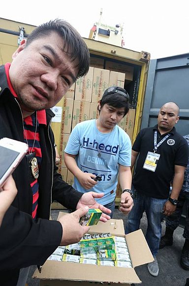Customs Intelligence and Investigation Service (CIIS) Director Neil Estrella examines the contents of the box that was shipped in two 40-footer vans. (CDN PHOTO/JUNJIE MENDOZA)