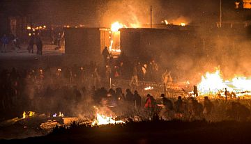 Migrants flee as a huge fire destroys the Grande-Synthe camp outside the northern French city of Dunkirk. /AFP