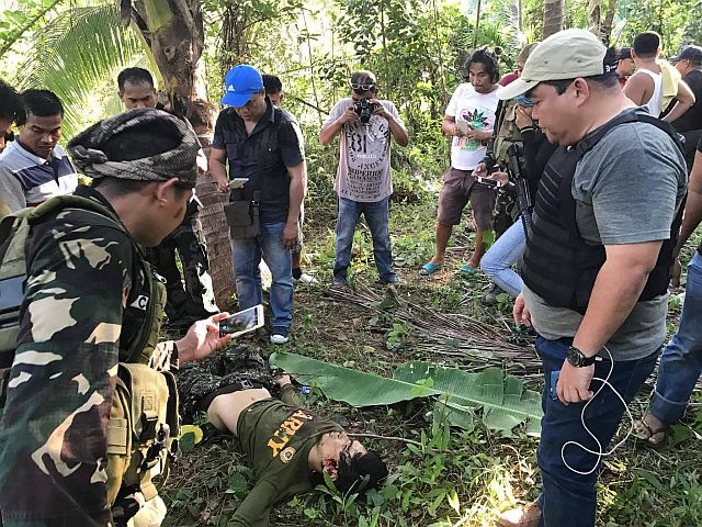 Joselito Melloria, a Boholano who became an Abu Sayyaf Group member, lies lifeless and surrounded by law enforcers following a gunfight with soldiers and policemen along a wooded area in Barangay Bacani in Clarin, Bohol, on April 22, 2017. CDN PHOTO/LEO UDTOHAN