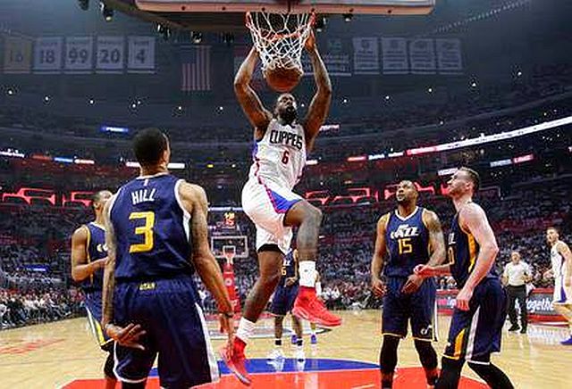 DeAndre Jordan of the Clippers dunks as four Jazz players look on. (AP)
