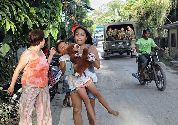 Residents of Barangay Cawayan, Inabanga town, Bohol province  run for their lives after two helicopter gunships continued pounding the armed groups’ position in Barangay Napo.